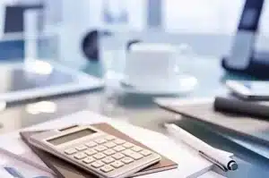 calculatrice stylo et tasse de cafe sur un bureau mfr rhone