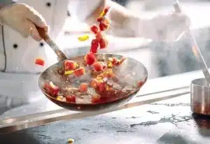 cuisine dans une poele par un chef en gants mfr rhone